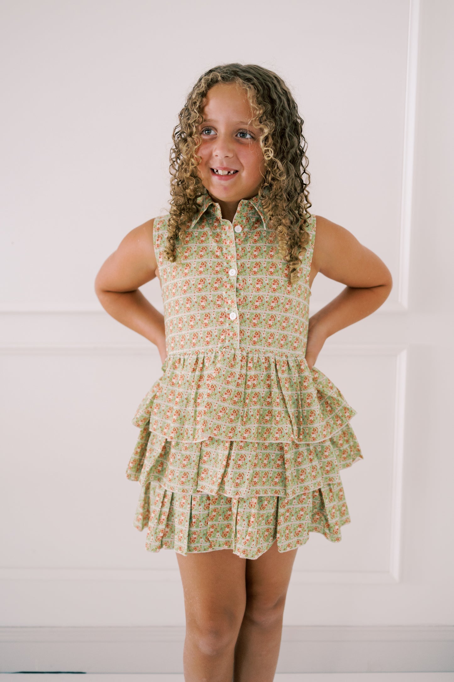 Young girl wearing a floral dress with a white background