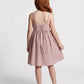 Person wearing a pink dress with a lace-up back on a white background