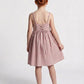 Young girl wearing a pink dress with a white background