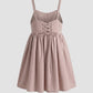 Pink dress with lace-up front and bow detail on a light gray background