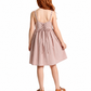A child model shown from the back wearing a dusty pink sleeveless dress with thin straps, a lace-up back, and a gathered skirt, paired with brown sandals on a white background.