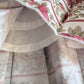 Close-up of floral fabric with red and green patterns on a beige background