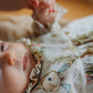 Baby wearing a patterned outfit with a soft focus background