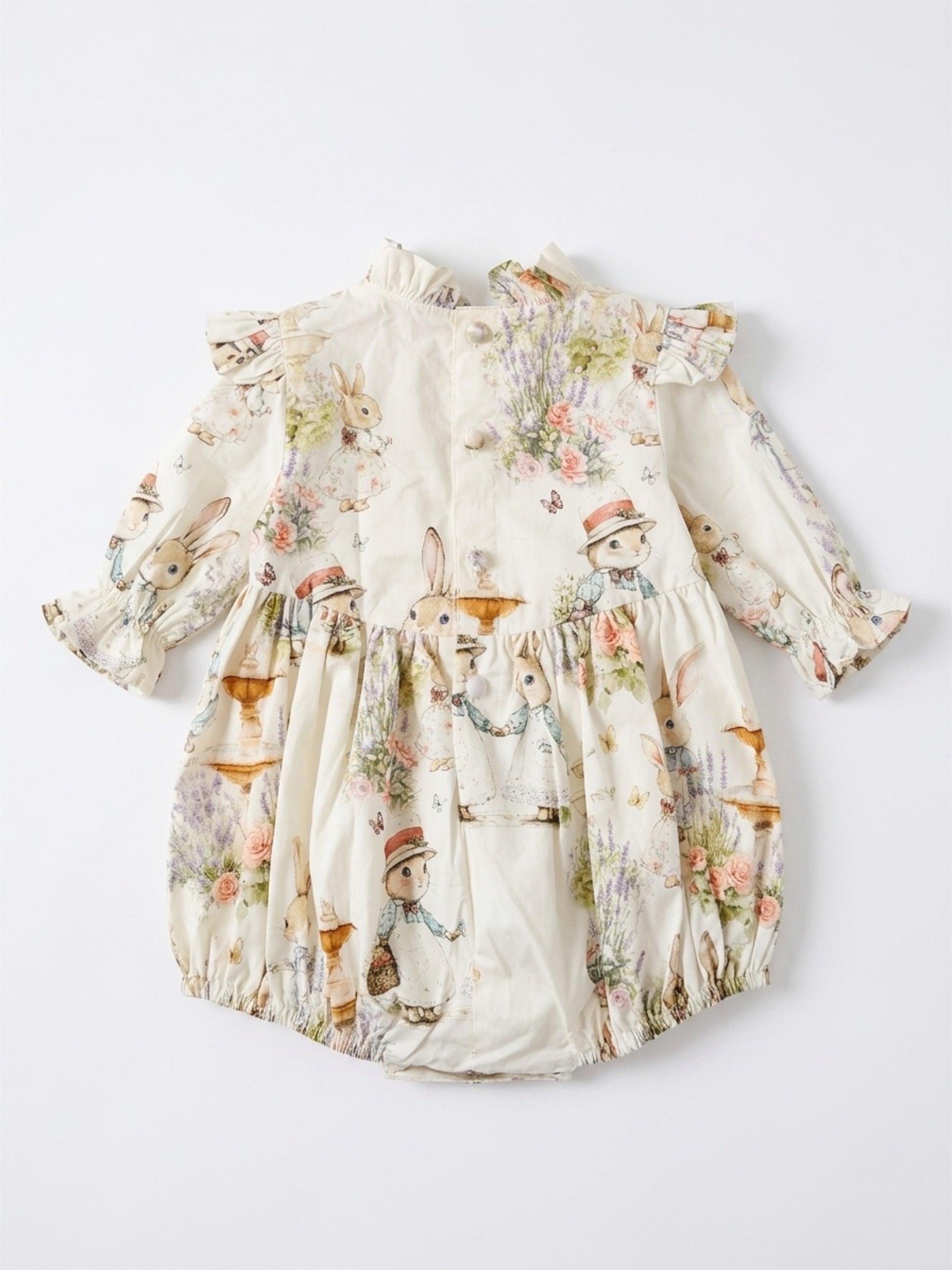 Floral baby romper with ruffled details on a white background