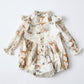 Floral baby romper with ruffled sleeves on a light gray background