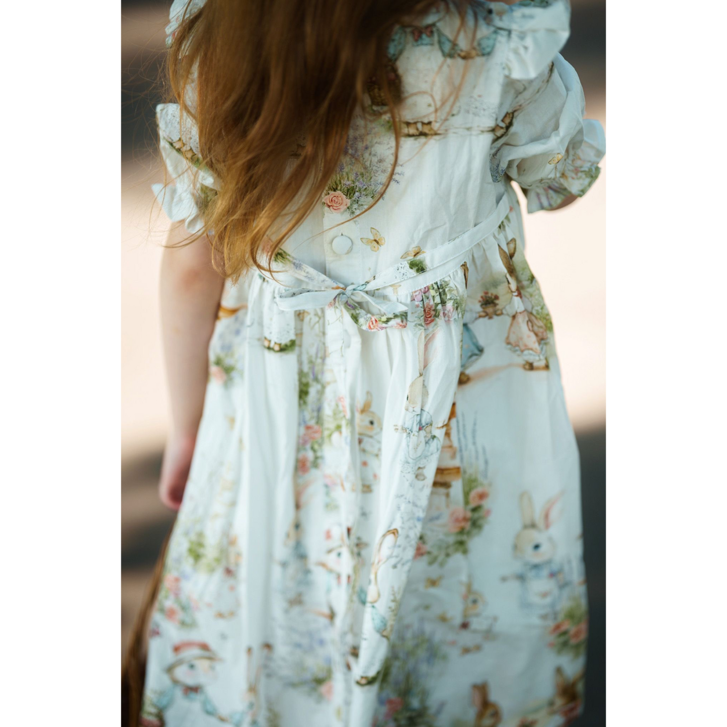 Child wearing a floral dress with animal prints on a blurred background