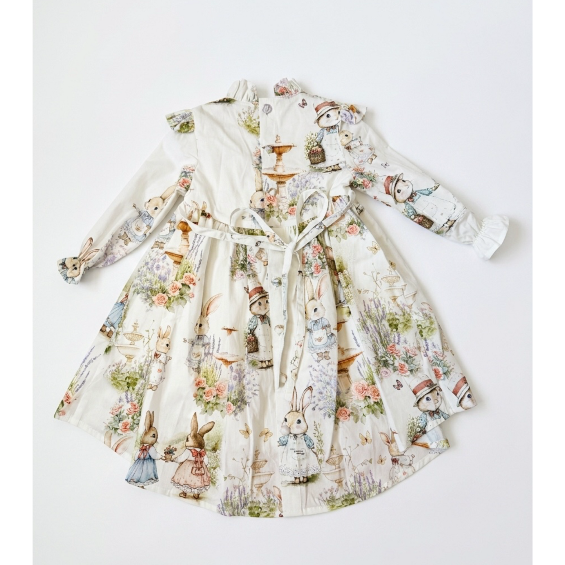 Children's dress with vintage-style rabbit print on a white background