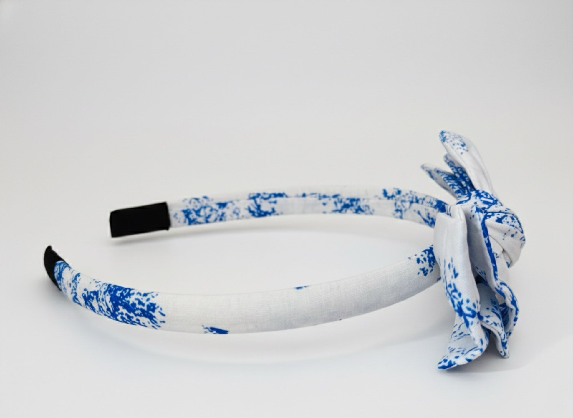 White headband with blue floral pattern on a white background