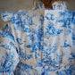 Person wearing a blue and white patterned shirt with a neutral background