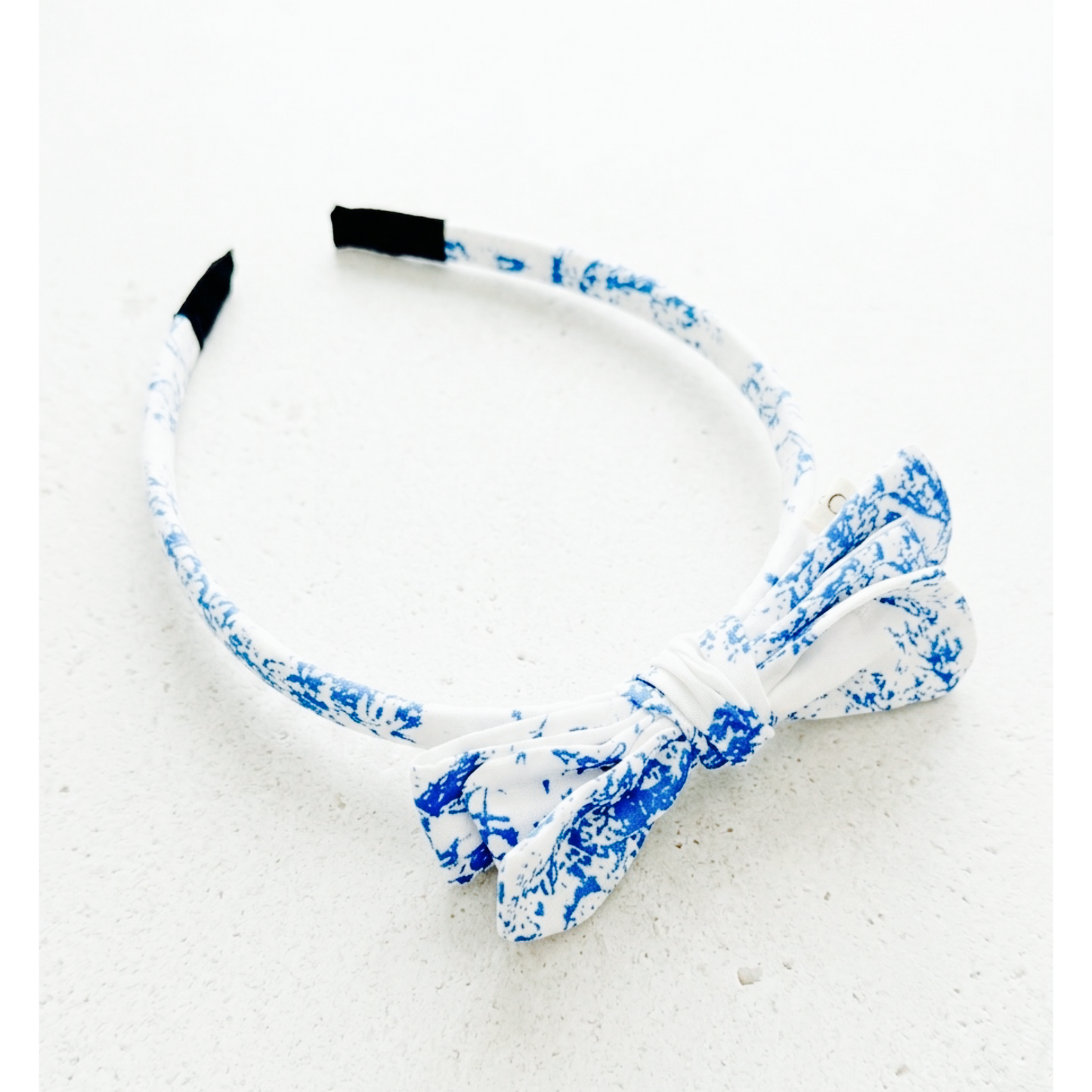 White headband with blue floral pattern on a white background