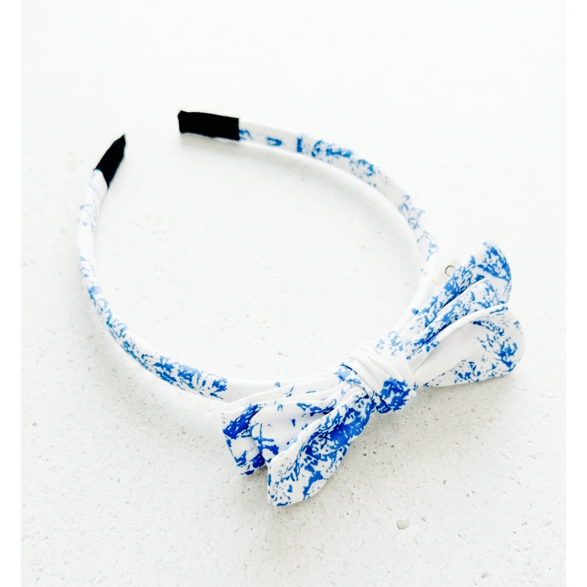 White headband with blue floral pattern on a white background