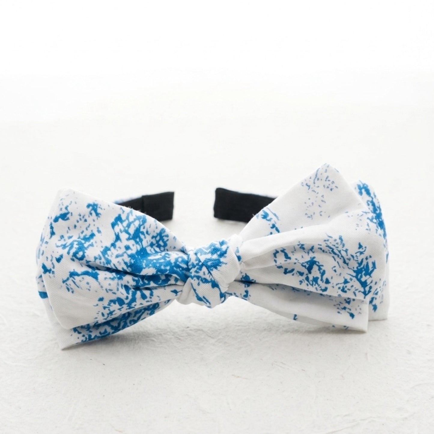 White bow tie with blue floral pattern on a white background