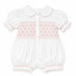 A white baby romper with short puff sleeves, a Peter Pan collar, and pink smocked detailing across the chest, shown on a plain white background.