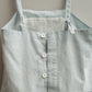 Light blue apron with buttons on a neutral background