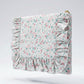 Floral patterned pouch with ruffled edges on a light gray background