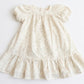 White dress with ruffled details on a light gray background