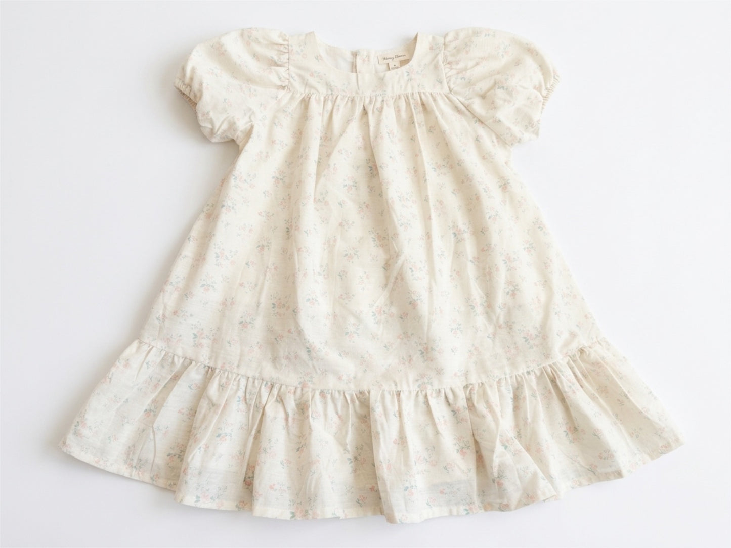 White dress with ruffled details on a light gray background