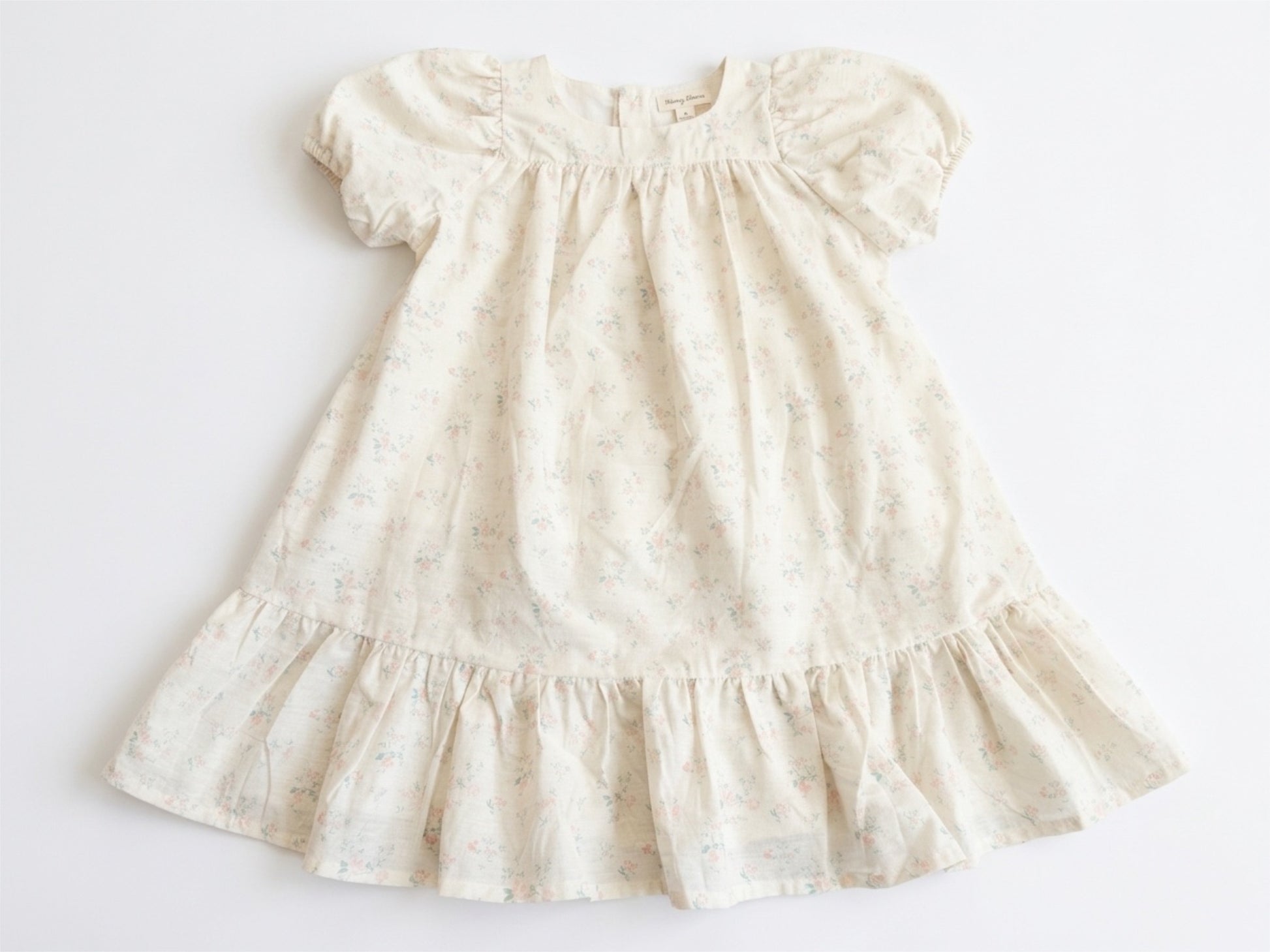 White dress with ruffled details on a light gray background