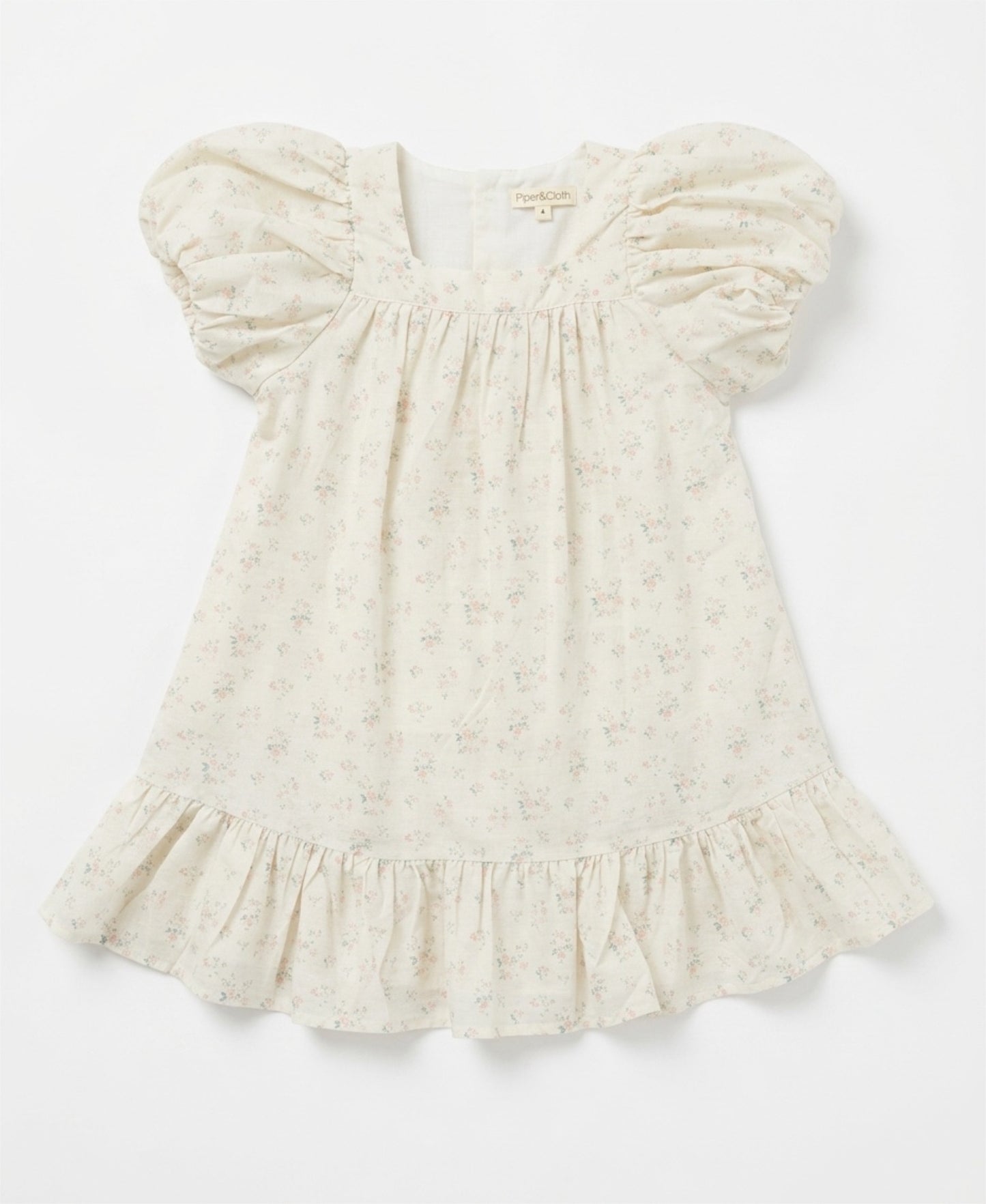 White baby dress with ruffled sleeves on a light gray background