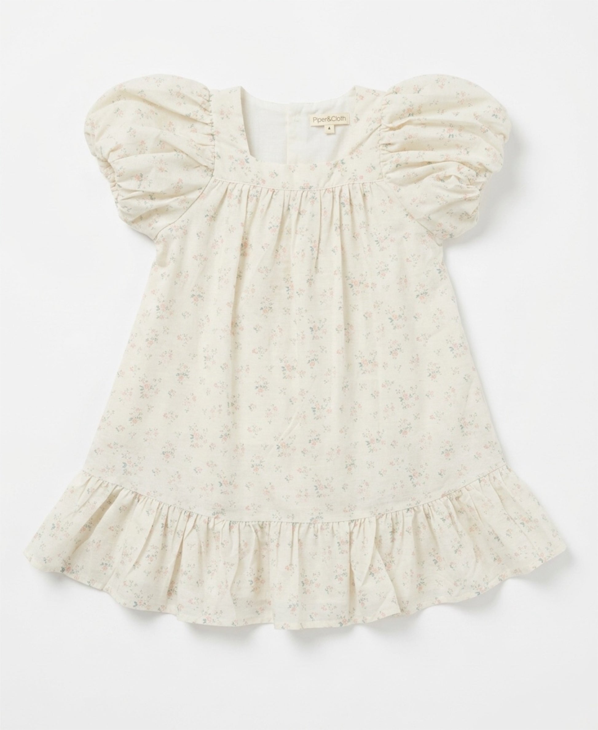 White baby dress with ruffled sleeves on a light gray background
