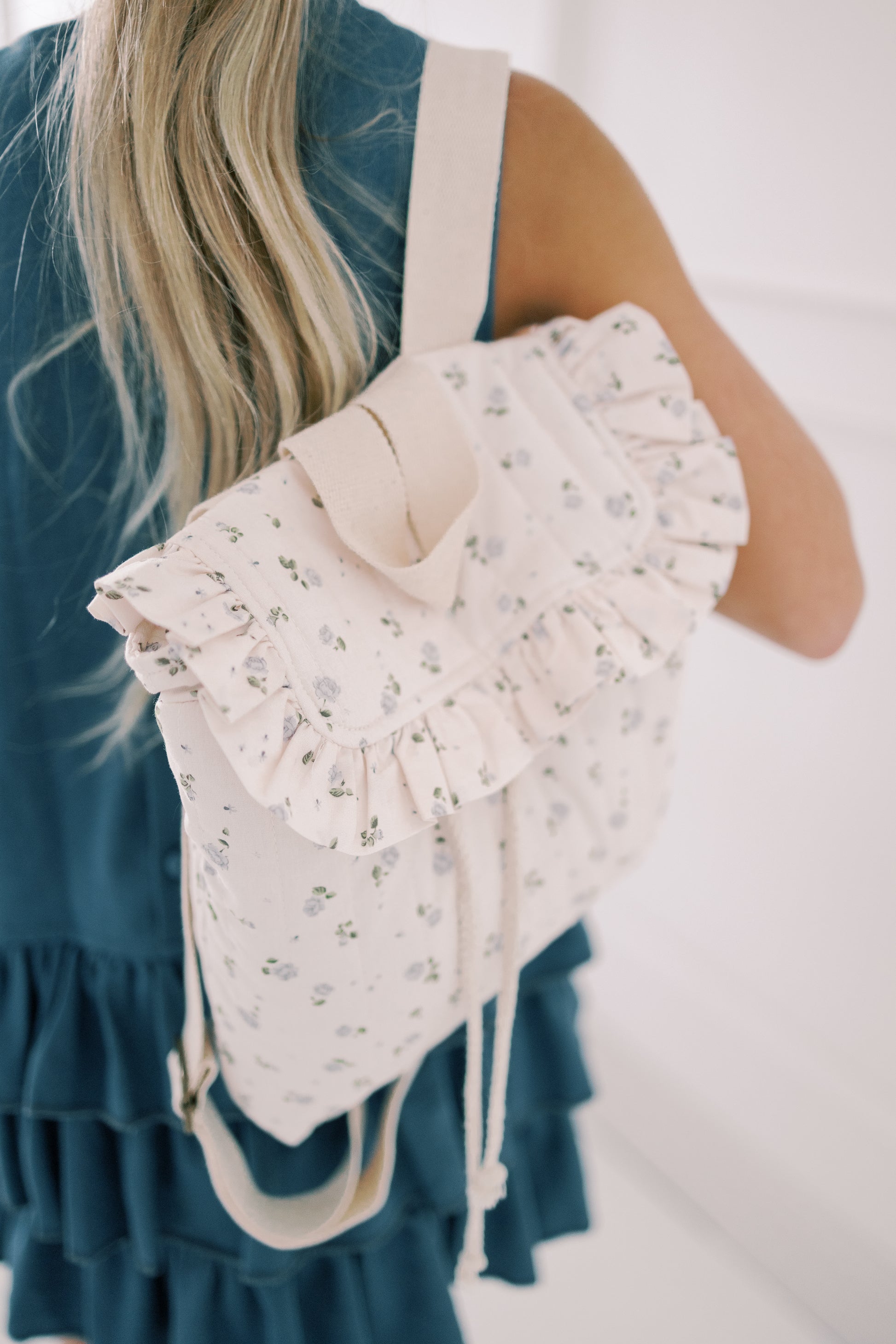 Floral backpack worn by a person with a blurred background