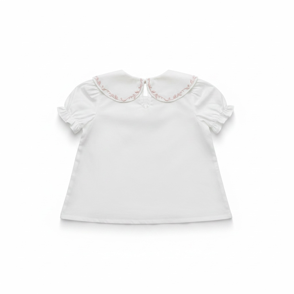 White blouse with ruffled sleeves and embroidered collar on a white background