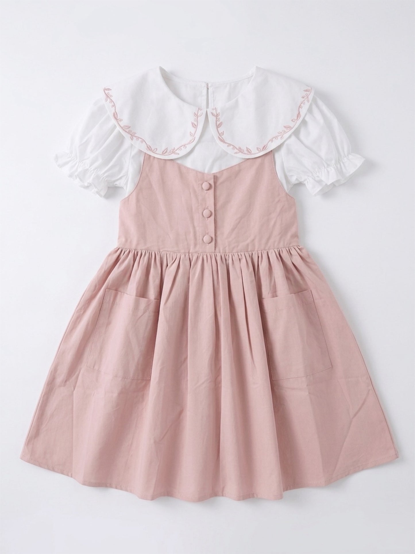 Pink dress with white collar on a light gray background