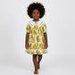 Young girl wearing a yellow floral dress on a white background