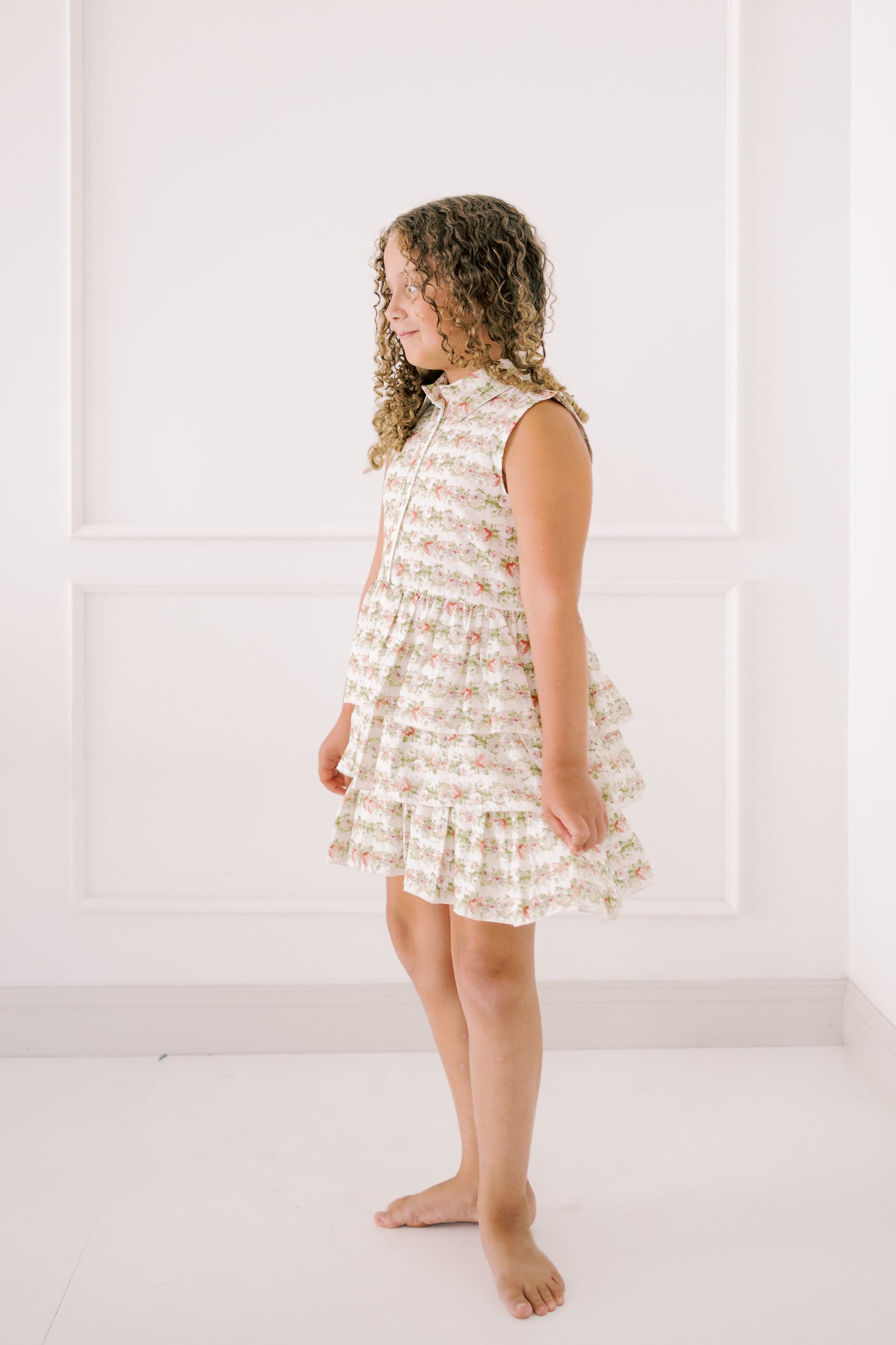 Girl wearing a floral dress against a white background