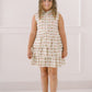 Young girl wearing a sleeveless floral dress against a white background