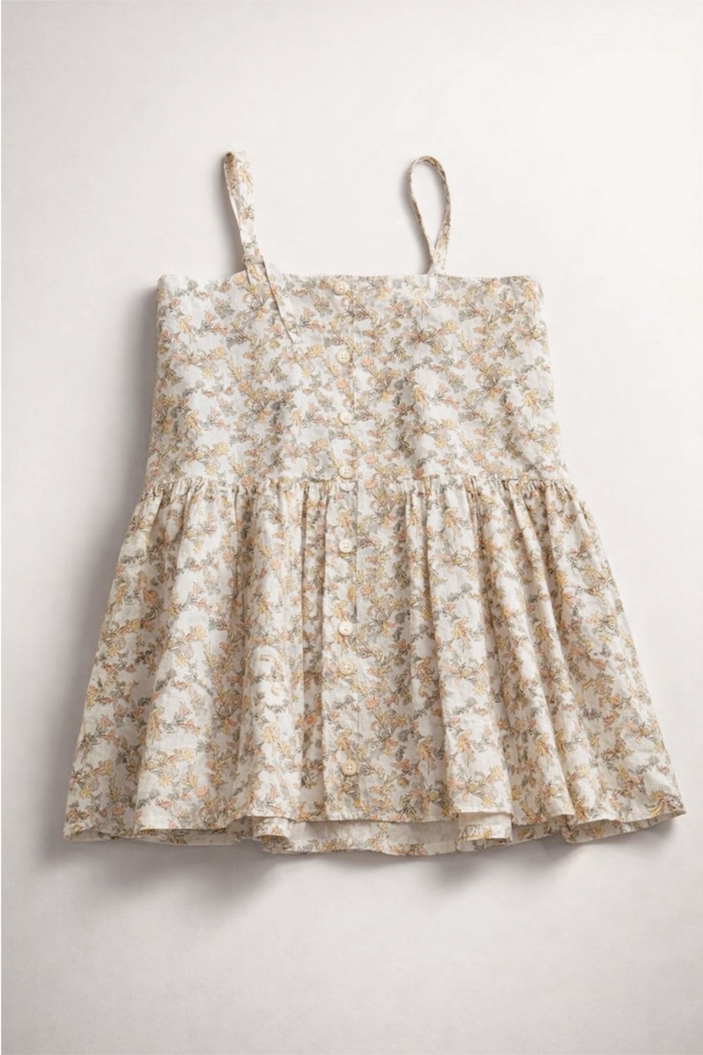 Floral dress with thin straps on a light gray background