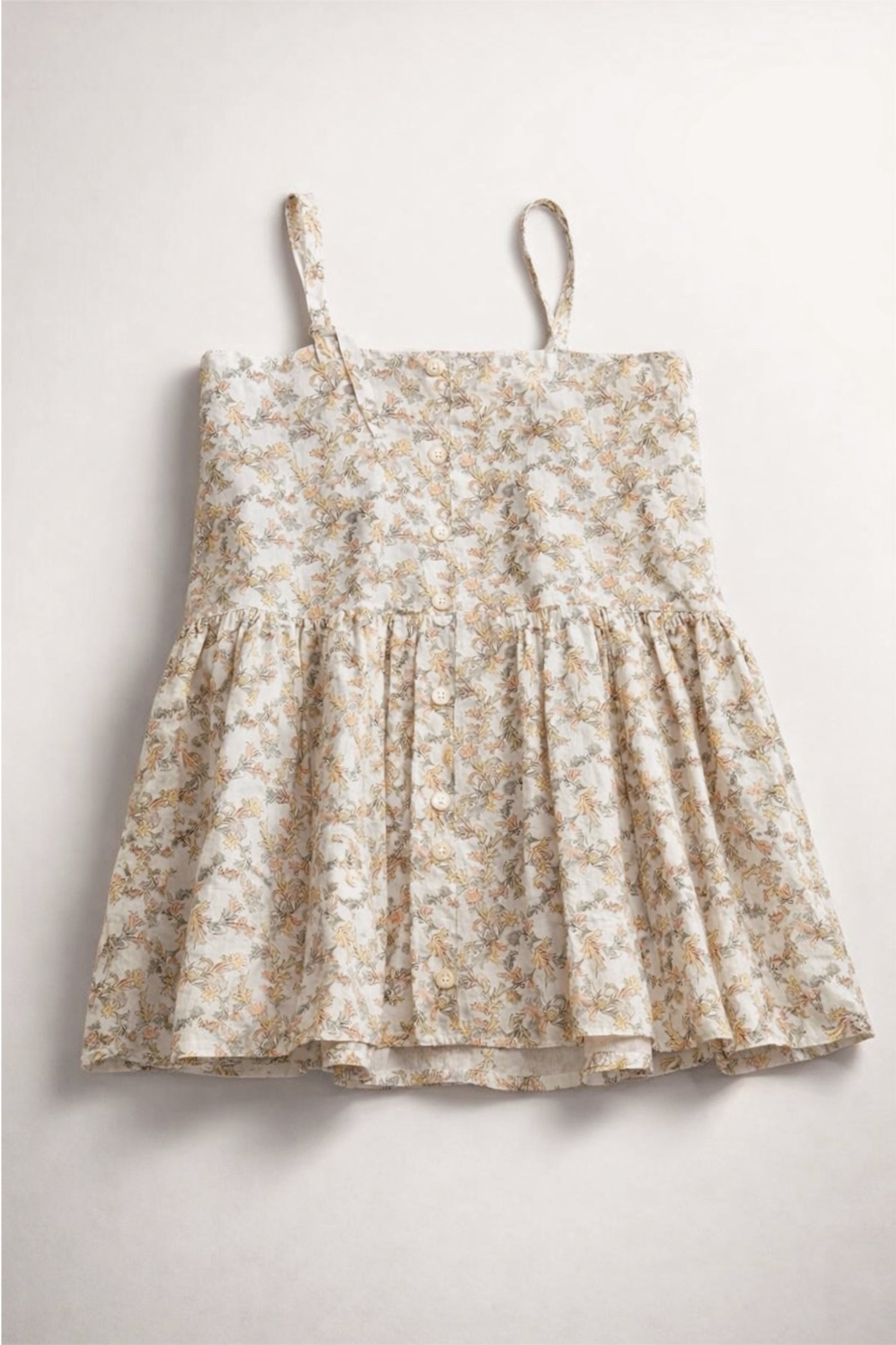 Floral dress with thin straps on a light gray background