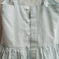 Light blue dress with buttons on a plain background