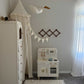 Children's playroom with a white toy kitchen, dresser, and decorative elements.