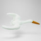 White plush toy swan with a yellow beak on a light gray background