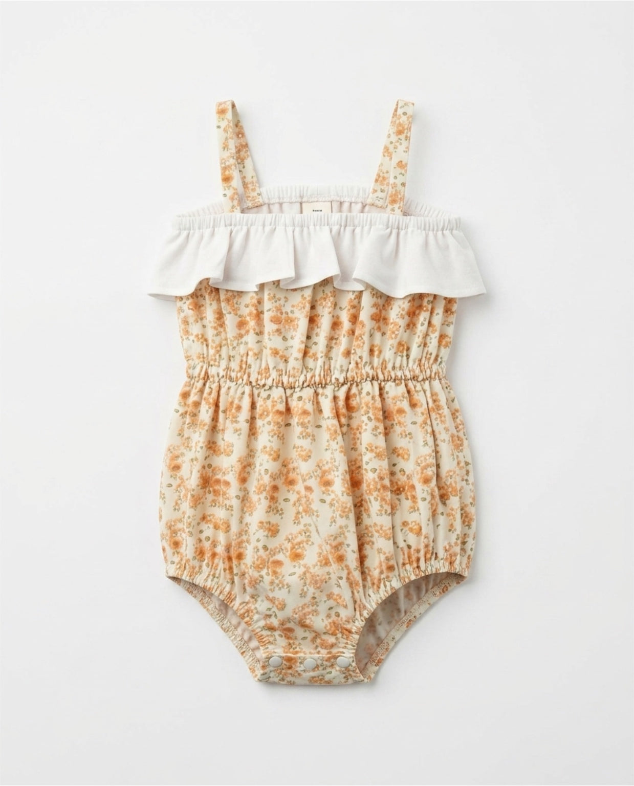 Floral baby romper with ruffled top on a white background