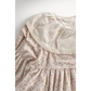 Close-up of a floral dress with lace trim on a white background