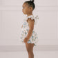 Young child wearing the Josie Bubble floral romper against a white background