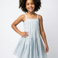 Young girl wearing a light blue dress against a white background