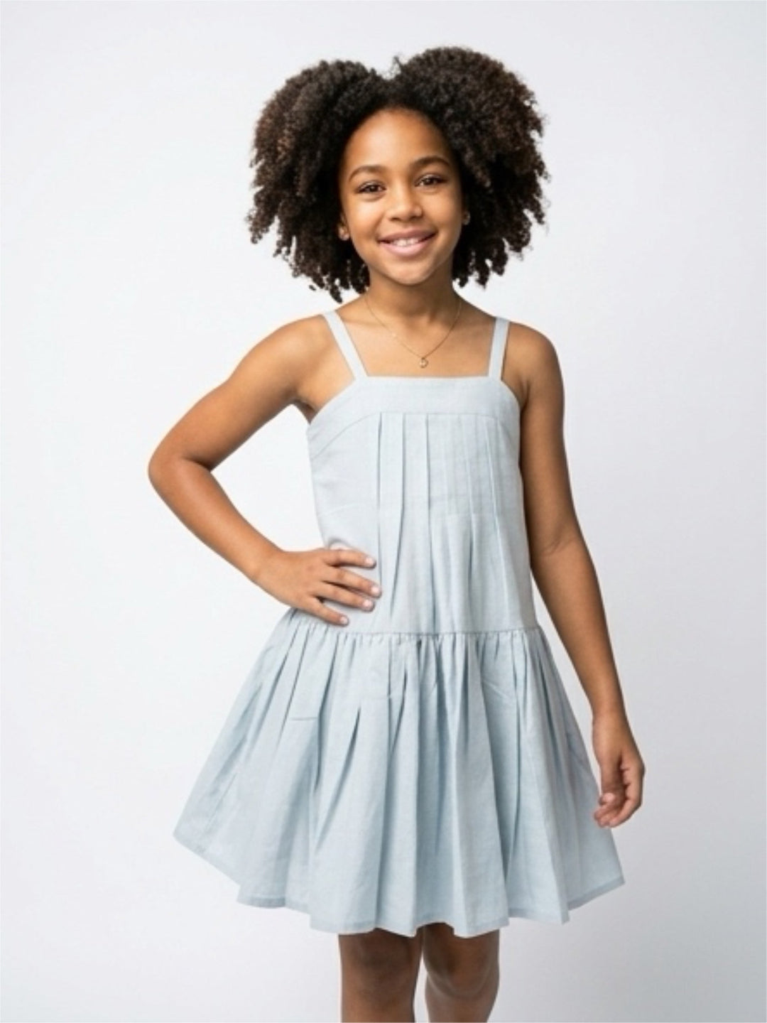 Young girl wearing a light blue dress against a white background