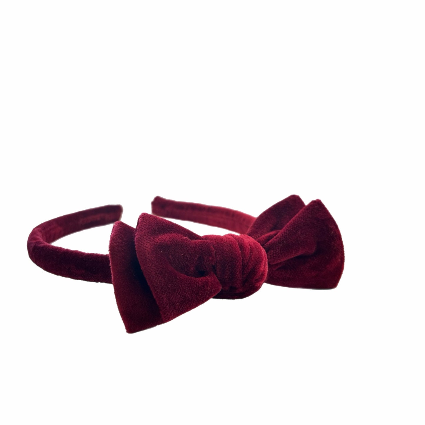 Red velvet headband with a bow on a white background