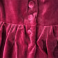 Close-up of a red velvet dress with buttons
