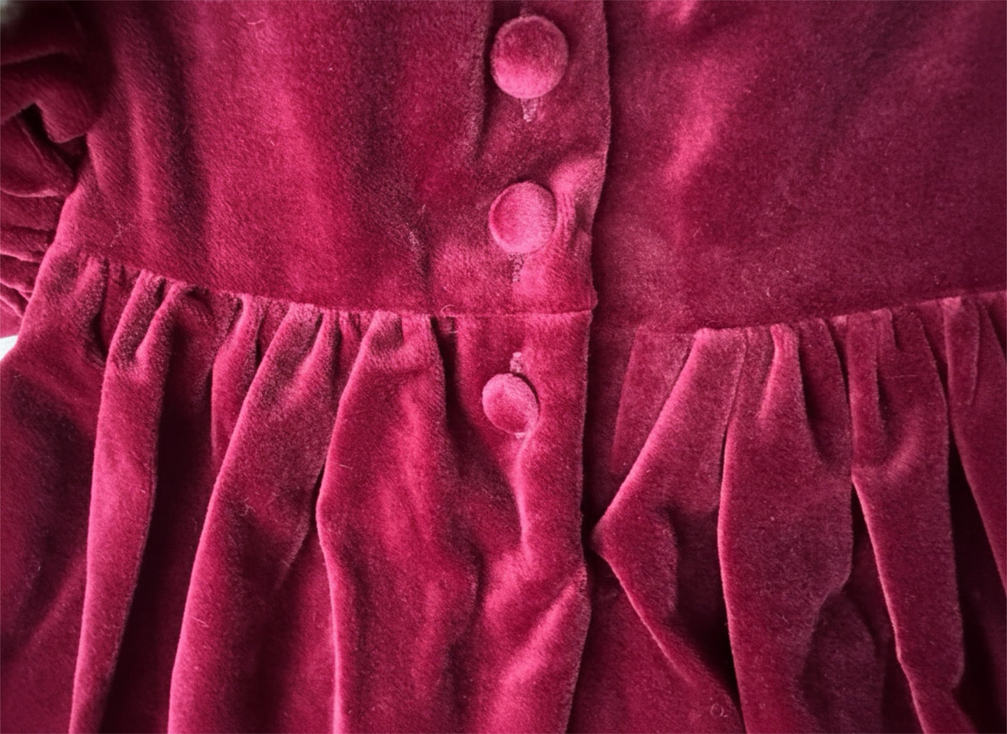 Close-up of a red velvet dress with buttons
