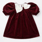 Maroon velvet dress with white collar on a white background