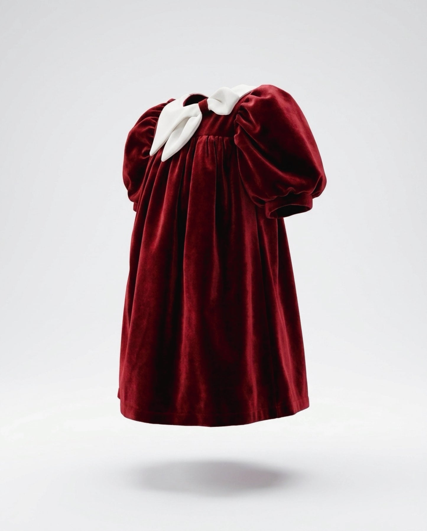 Red velvet dress with white trim on a light gray background
