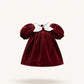 Red velvet dress with white collar on a beige background