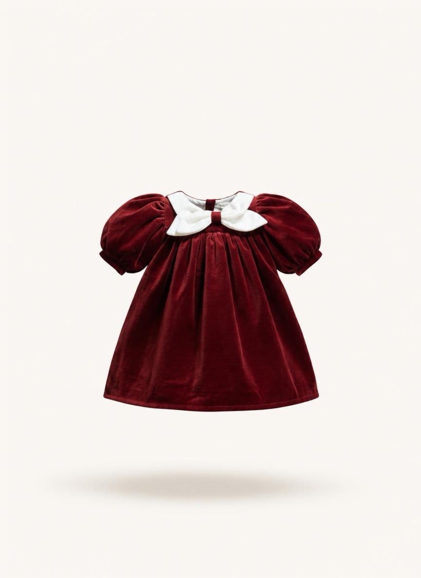 Red velvet dress with white collar on a beige background