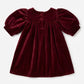 Maroon velvet dress with puff sleeves on a white background