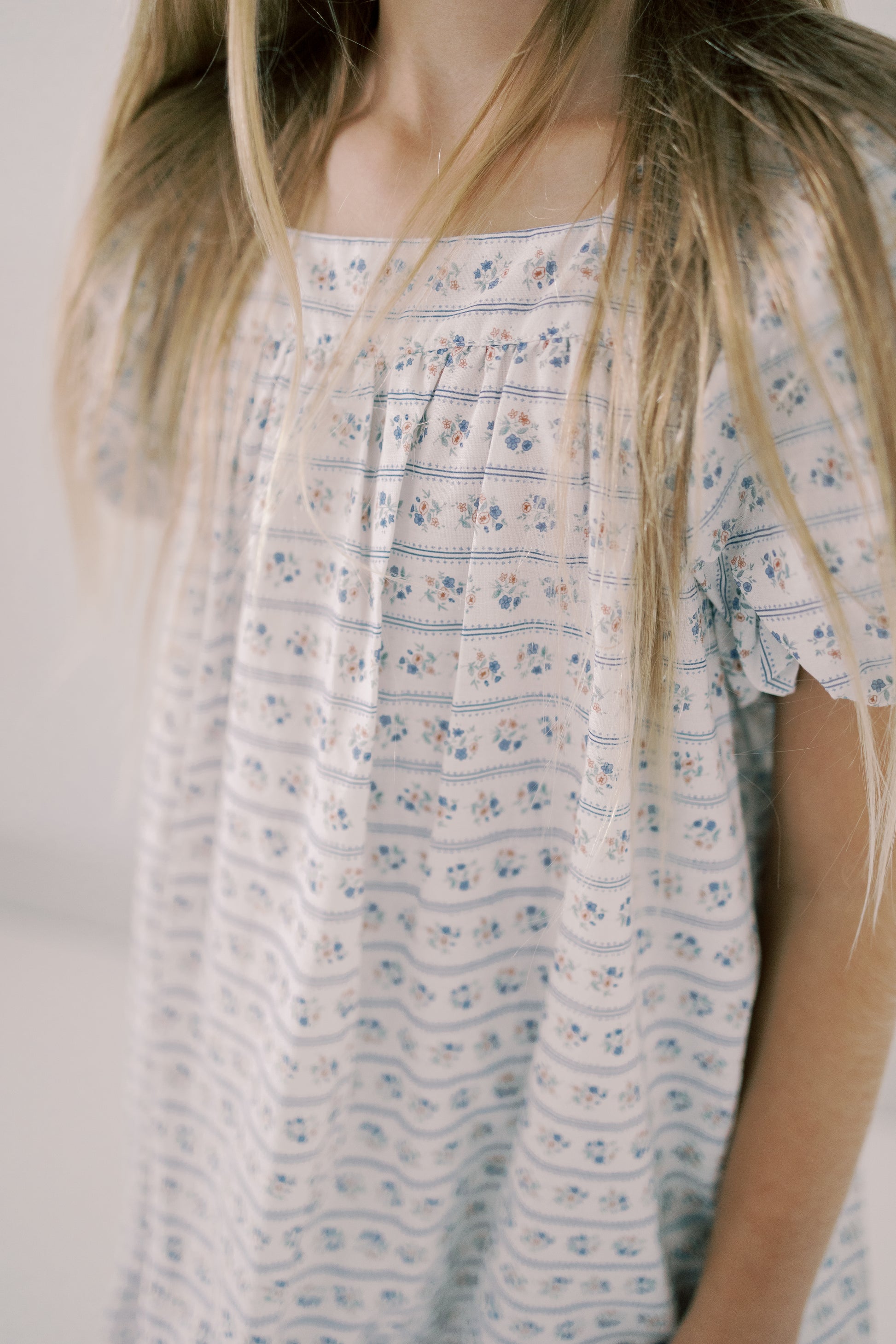 Girl wearing a floral dress with a plain background