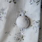 White spherical ornament on a floral fabric background